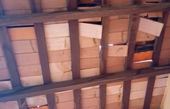 Techo de la Escuela Básica 207 Blas Garay con tejas de cerámica y vigas de madera, mostrando deterioro importante.