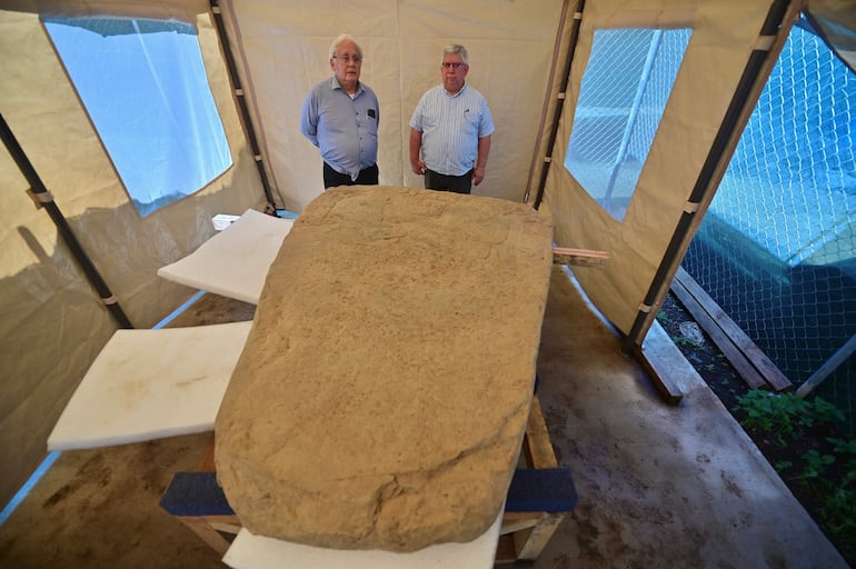 Los arqueólogos mexicanos Lino Espinoza (izq.) y Alberto Vázquez (der.), del Instituto Nacional de Antropología e Historia (INAH), posan junto a una estela de 2,5 toneladas hallada en un sitio arqueológico de Coatepec, en el estado de Veracruz, México, el 18 de junio de 2026.
