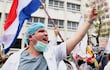 Un médico participa en una protesta este lunes, en Asunción (Paraguay). Médicos del sector público marcharon y protagonizaron concentraciones en Paraguay, en el primer día de una huelga general que han convocado hasta el viernes para exigir un reajuste salarial, mejores condiciones laborales y la dotación de insumos y medicamentos en los hospitales. EFE/ Nina Osorio