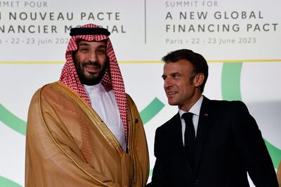 El presidente de Francia, Emmanuel Macron (d) saluda al príncipe heredero saudí, Mohammed bin Salman, en el arranque de la Cumbre de París para un nuevo pacto financiero global. (AFP)
