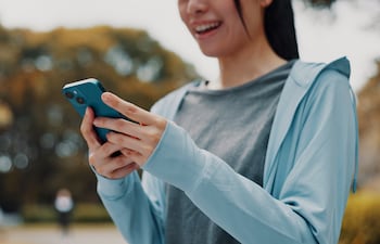 Mujer con las manos en un celular, concepto de uso de apps.