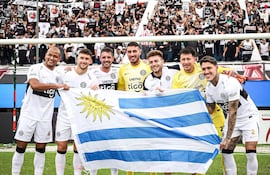 Legión uruguaya en plena celebración de la conquista del título del Apertura 2026 con Olimpia. Los tres de la izquierda dejan el club: Lucas Morales, Rodrigo Pérez y Alejandro Silva. Los demás continúan: Gastón Olveira (nacionalizado, integrante de la Albirroja), Faustino Barone (nacido en Paraguay), Sebastián Lentinelly y Bryan Bentaberry.