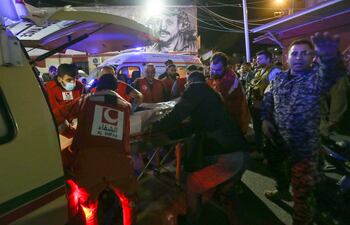Trabajadores médicos trasladan el cuerpo de una persona fallecida en el bombardeo israelí al campo de refugiados cerca de la ciudad libanesa de Sidón.