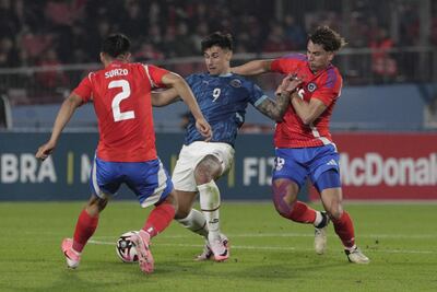 Adam Bareiro (c), jugador de la selección paraguaya, pelea por el balón con Gabriel Suazo (i) y Rodrigo Echevarría (d), futbolistas de Chile, en el amistoso internacional en el estadio Nacional, en Santiago, Chile.