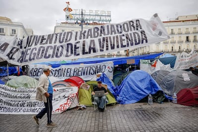 Un joven con su ordenador en la acampada que permanece en la Puerta del Sol en protesta por la crisis de la vivienda, este martes, en el que el Gobierno prevé volver a aprobar los decretos en materia de vivienda para llevarlos a la Diputación Permanente.