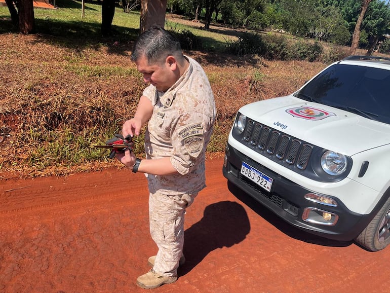 Un oficial de la comisaría 33° de Culantrillo observa el arma que supuestamente fue utilizado en el ataque.