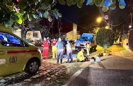 Bomberos asisten a la víctima en el lugar del incidente, en el barrio Mburucuyá de Asunción.