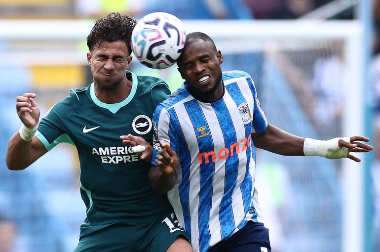 El delantero griego del Brighton, Charalampos Kostoulas, y el centrocampista nigeriano del Coventry City, Frank Onyeka, saltan para cabecear el balón durante el partido por la Premier League inglesa.