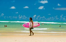 Una mujer surfea en la playa de Praia da Pipa, Brasil.