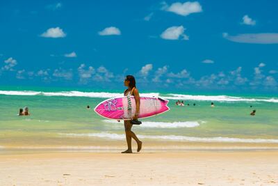 Una mujer surfea en la playa de Praia da Pipa, Brasil.