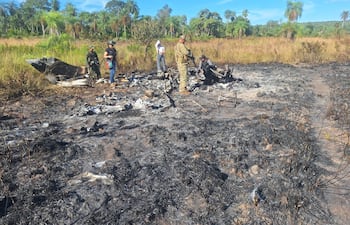 La fiscala Carolina Quevedo, con militares y policías, en el lugar donde se quemó la avioneta boliviana.-optimized.jpg