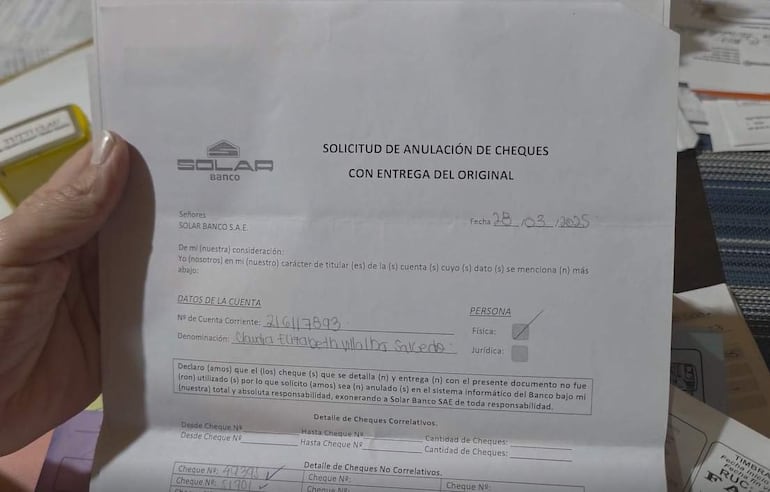 Documento de anulación de cheques de Solar Banco S.A.E. con mano visible y fondo de papeles.