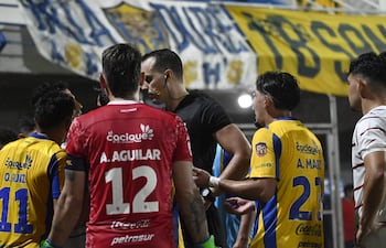 El portero del Sportivo Luqueño Alfredo Aguilar se acerca al árbitro David Ojeda para pedir una explicación del porqué le exhibieron la tarjeta roja directa.