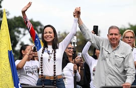 El candidato presidencial opositor venezolano Edmundo González Urrutia (der.) y la líder opositora María Corina Machado saludan durante su mitin de cierre de campaña en Caracas el 25 de julio de 2024.