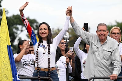 El candidato presidencial opositor venezolano Edmundo González Urrutia (der.) y la líder opositora María Corina Machado saludan durante su mitin de cierre de campaña en Caracas el 25 de julio de 2024.