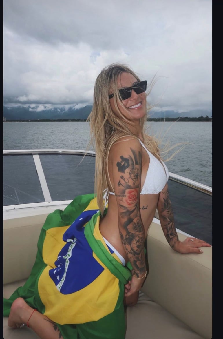 Tatiana Marset posa tapada con una bandera de Brasil, en un yate, en medio del mar.