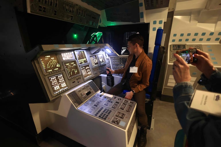 Personas interactúan con los controles del transbordador espacial Endeavour de la NASA, exhibido en posición de lanzamiento en el Centro Aéreo y Espacial Samuel Oschin, durante una presentación para los medios en el Centro de Ciencias de California, en Los Ángeles, el 28 de octubre de 2026.