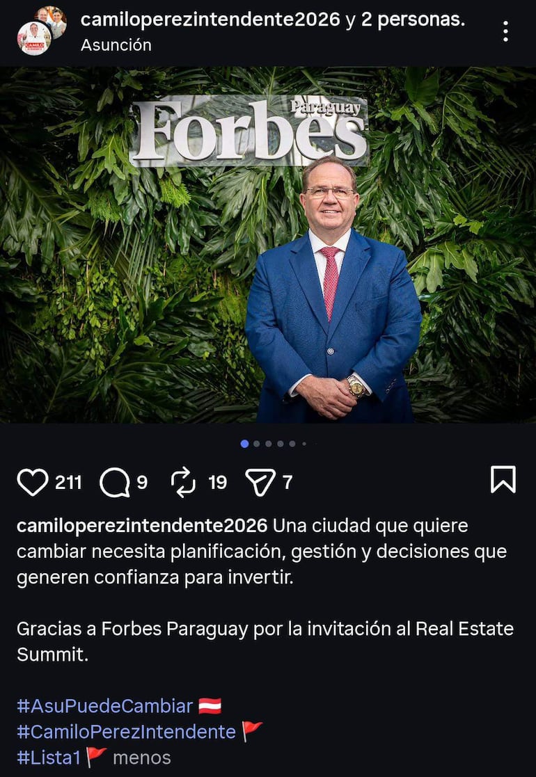 Camilo Pérez en traje azul con corbata roja, posando en un fondo con plantas y el logo de Forbes Paraguay.