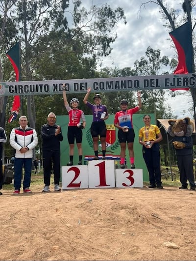 El podio femenino que levanta el trofeo con gran entisiasmo.