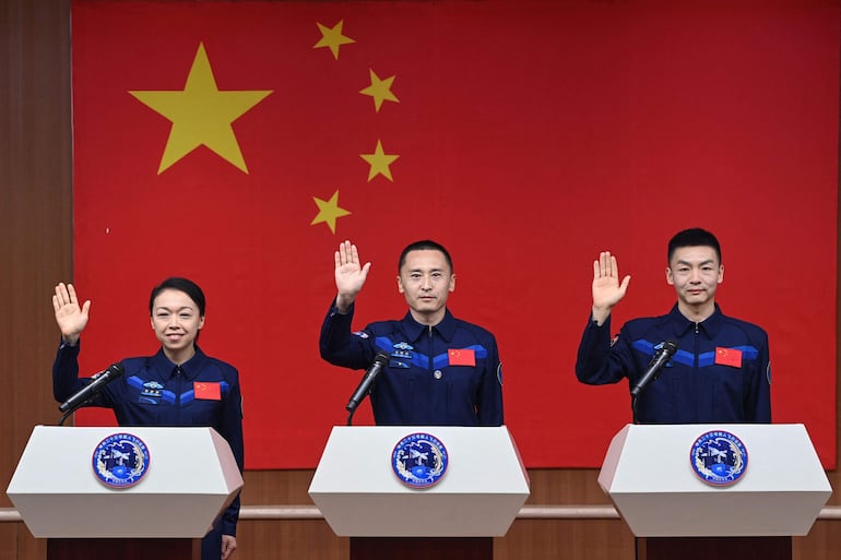 Los astronautas de la misión espacial china Shenzhou-23, Lai Ka-ying (I), Zhu Yangzhu (C) y Zhang Zhiyuan (D), saludan durante una conferencia de prensa antes del lanzamiento de la misión en el Centro de Lanzamiento de Satélites de Jiuquan, en el desierto de Gobi, en Jiuquan, provincia de Gansu, en el noroeste de China, el 23 de mayo de 2026.