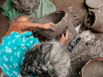 Una maestra artesana trabaja con el ñai’û (barro negro) para dar forma a distintos elementos.