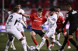 El mediocampista de Independiente de Avellaneda Mateo Pérez Curci maneja el esférico redeado de las marcas de Ezequiel Bonifacio, Leonard Costa y Alex Arce.