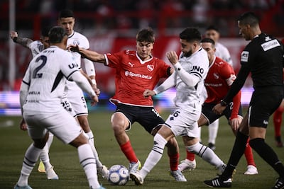 El mediocampista de Independiente de Avellaneda Mateo Pérez Curci maneja el esférico redeado de las marcas de Ezequiel Bonifacio, Leonard Costa y Alex Arce.