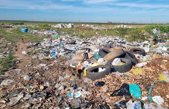Basural en Villa Florida, con montañas de residuos plásticos y neumáticos en un área rural, sin personas presentes.