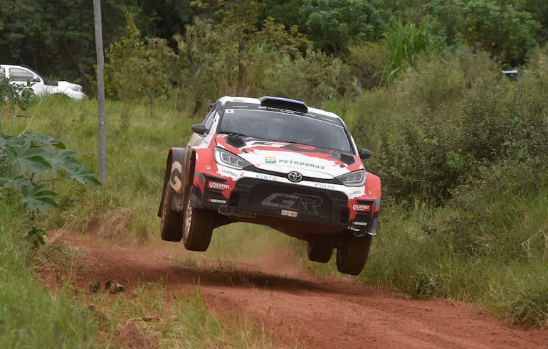 Automóvil Toyota de rally en acción, saltando sobre terreno de tierra, con publicidad de Petrobras visible.