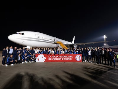 Los componentes de la selección paraguaya de fútbol posando con la frase "La raza paraguaya es Vencer o Morir, teniendo de fondo la aeronave que los traslada rumbo al Mundial 2026.