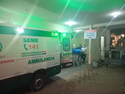 Dos trabajadores de salud en uniforme claro trasladan a Milciades Ramón Benítez en camilla hacia un área de emergencia.