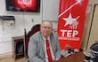 Rubén Rolón, hombre de edad avanzada con traje gris y corbata roja, sentado en un escritorio con banderín del Tribunal Electoral Partidario detrás.