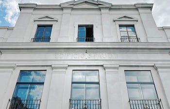 Fachada del Edificio Staudt, blanco con detalles arquitectónicos, molduras y balcones, bajo un cielo parcialmente nublado.