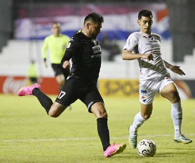 El delantero de Tacuary, Jorge Ortega se alista para sacar el disparo ante la apresurada marca del defensor tricolor Fernando Román.