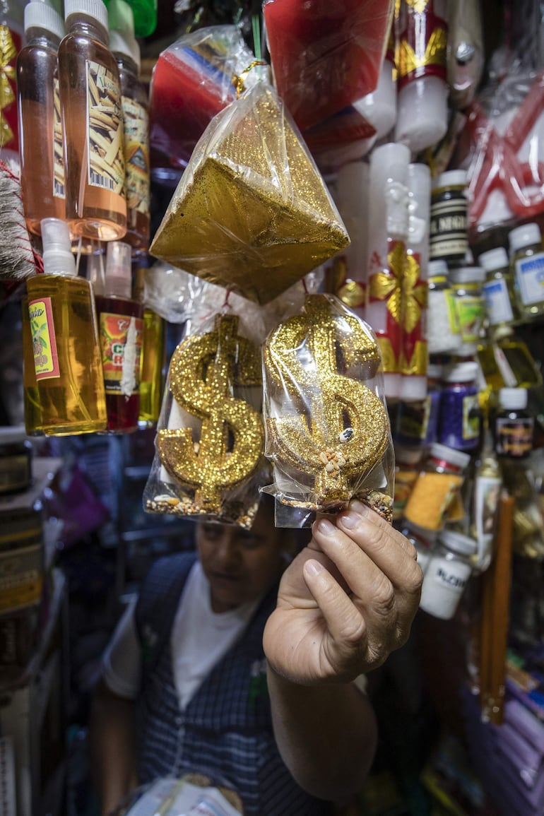 Una comerciante muestra productos esotéricos para rituales de fin de año este martes, en el Mercado de Sonora, en Ciudad de México.