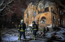 Bomberos frente a un edificio dañado en el ataque ruso de este viernes, en Kiev.