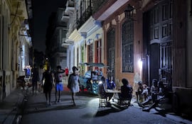 Personas alumbran con lámparas una calle, durante un apagón en La Habana (Cuba).