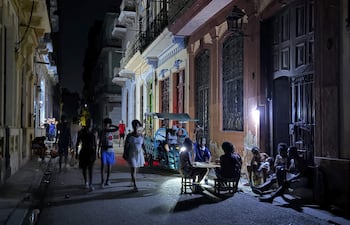 Personas alumbran con lámparas una calle, durante un apagón en La Habana (Cuba).