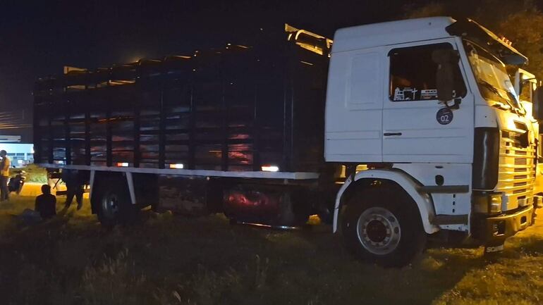 Camión blanco aparcado en entorno nocturno, sin personas visibles, en un área rural con escasa iluminación.