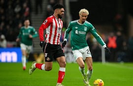 El delantero francés del Liverpool, Hugo Ekitike (n.° 22), corre con el balón bajo la presión del defensa paraguayo del Sunderland (n.° 15), Omar Alderete, durante el partido de la Premier League inglesa entre el Sunderland y el Liverpool en el Stadium of Light de Sunderland, noreste de Inglaterra, el 11 de febrero de 2026. (Foto de ANDY BUCHANAN / AFP)