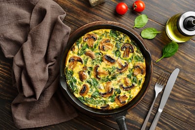 Frittata con espinacas y champiñones en sartén de hierro fundido.