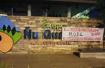 Banner en la entrada del Parque Ñu Guasu que expresa oposición a la privatización, con logotipo del parque y mensaje claro.