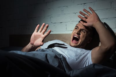 Hombre se despierta de una pesadilla.