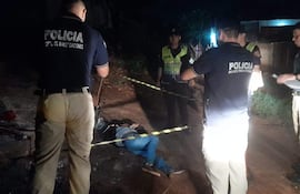Policías investigan una escena del crimen donde hay un cuerpo sin vida en el suelo en Pedro Juan Caballero.