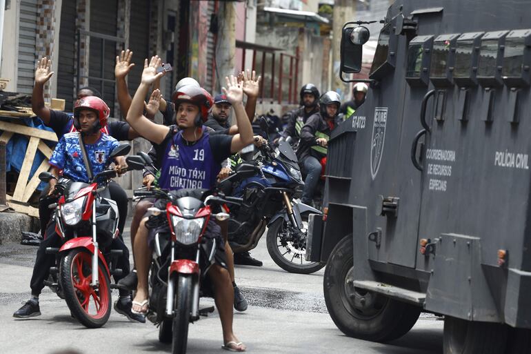 Personas reaccionan durante un operativo de la Policía d Río de Janeiro, hoy, en Río de Janeiro (Brasil). 