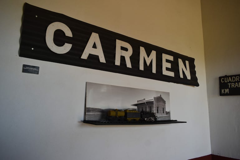 Interior del Museo Histórico Ferroviario con cartel de 'CARMEN' y vitrina que muestra fotografía histórica y modelo de tren.