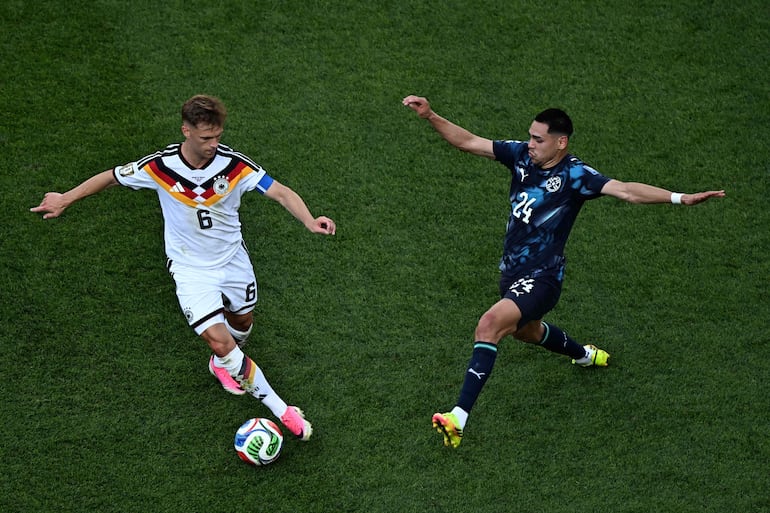 El defensor de Alemania Joshua Kimmich corre con el balón dejando atrás al delantero de Paraguay Gustavo Caballero durante el partido de fútbol de los dieciseisavos de final de la Copa Mundial 2026 entre Alemania y Paraguay en el Boston Stadium en Foxborough.