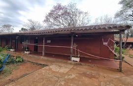 Entorno desértico del Colegio Nacional Rigoberto Caballero, con vegetación y cinta de precaución por riesgo.
