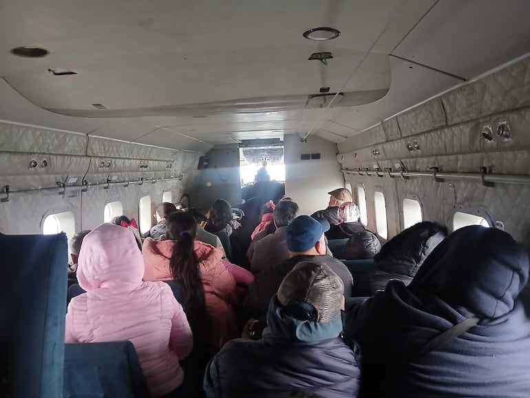 Pasajeros abrigados dentro del avion militar