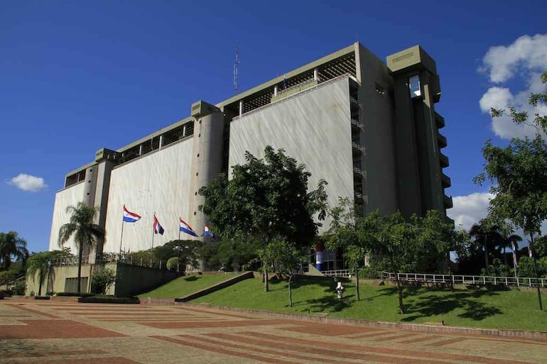 Edificio del BCP en un día soleado, rodeado de césped y árboles, sin personas visibles.